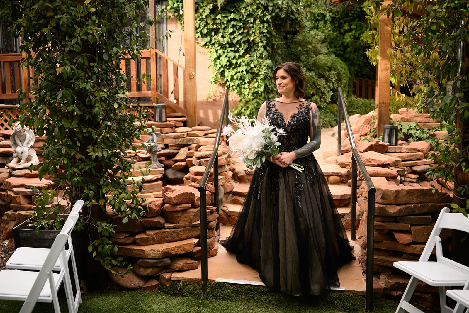Woman in a black wedding dress walking down the stairs